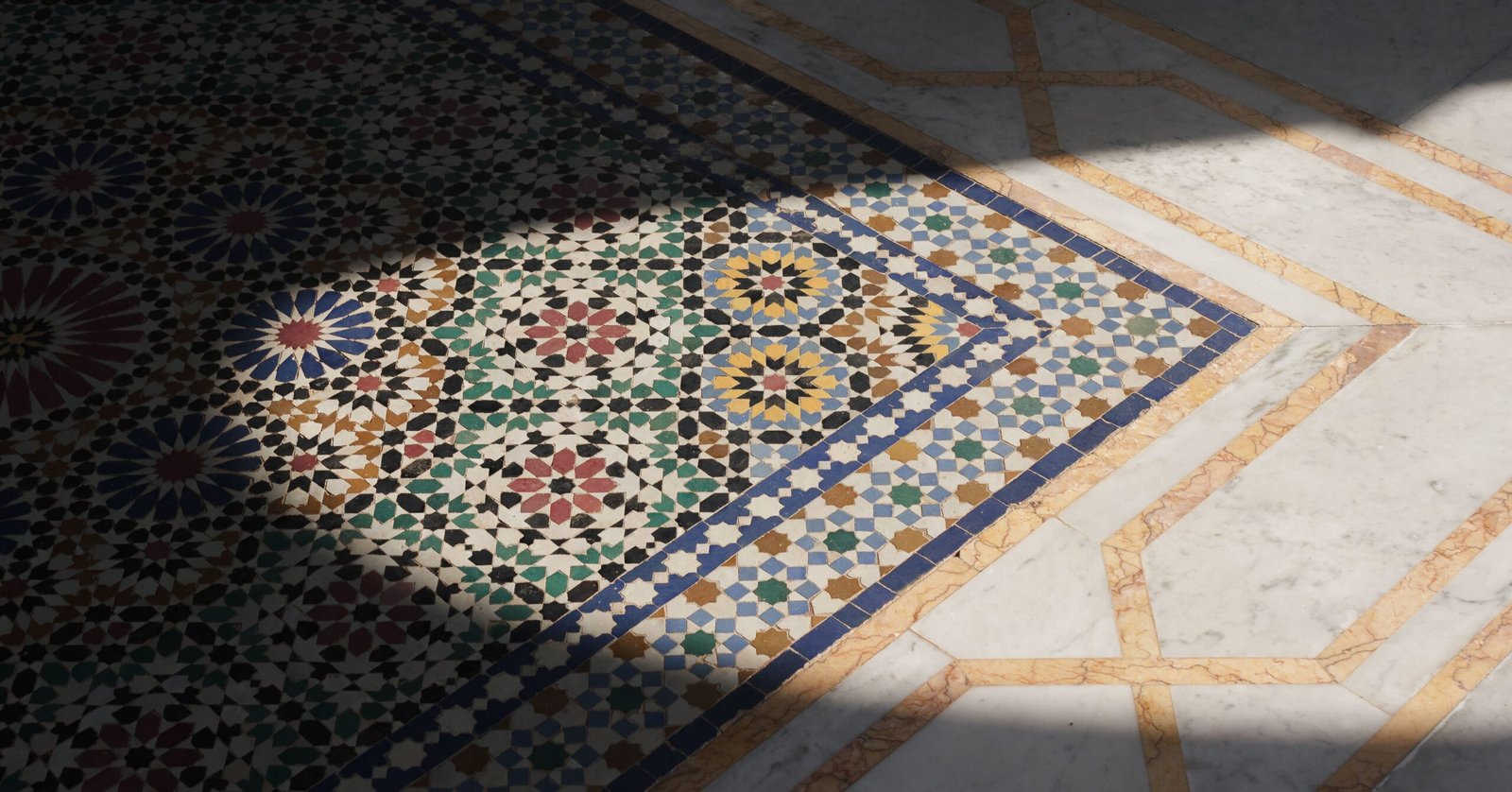 Intricate Moroccan mosaic tile flooring design with shadow contrast and vibrant colors.